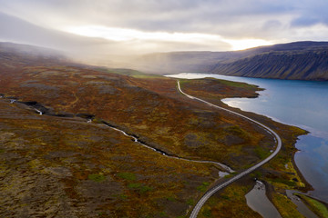 A curvy road between the mountains and see in Highlands, Iceland