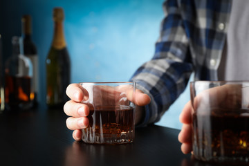 Men holding glasses of whiskey at the bar, space for text