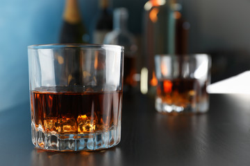 Glasses of whiskey on bar counter, close up and space for text