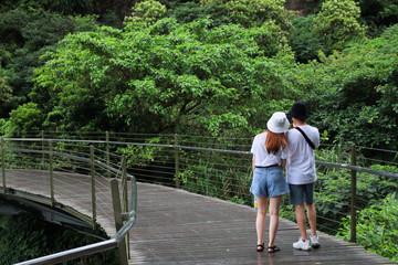 picture of young couple wearing white t-shirt are standing on wooden bridge walkway. Jiufen-Jinguashi , Taiwan