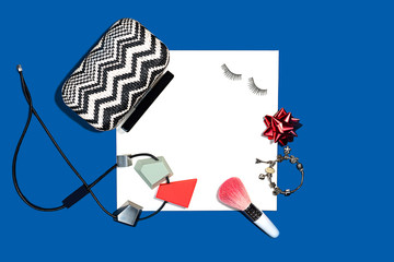 Female fashion layout with white paper sheet and femail accessories on classic blue color background.