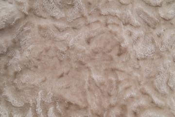 Fluffy beige plaid background, close up. Delicate baby pastel fabric with waves and pleats. Wrinkled beige warm blanket background