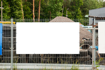 Blank white advertising banner on the fence at industrial area