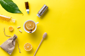 Illness concept. Composition alternative medicine. Herbal tea, ginger and lemon on a yellow background. Child's health. Flat lay. View from above. Copy space