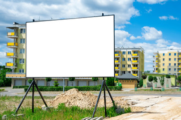 Blank white billboard for advertisement in the front of construction site against the residential...