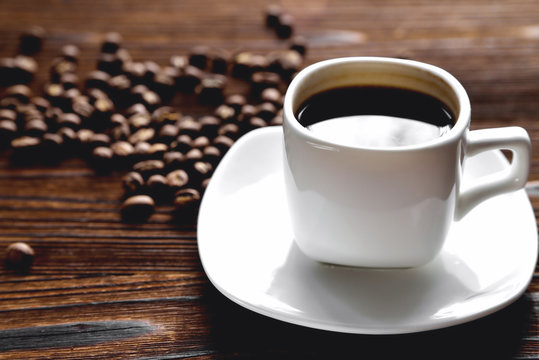 white coffee cup, morning side light coffee beans, natural wooden background © Александр Юркевич