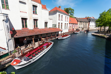 Fototapeta na wymiar Cityscape of Bruges overlooking the canal and boats for excursions.