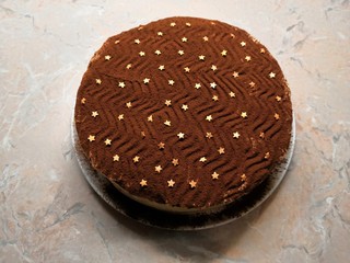 Delicious homemade chocolate cake sprinkled with cocoa powder and decorated with golden stars
