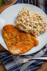 Fried pork chop in breadcrumbs, served with vegetable salad.