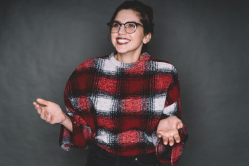 Fototapeta premium Smiling young woman in glasses with raised hands