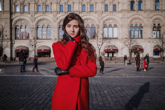 Happy women walking in red coat at the red square in Moscow