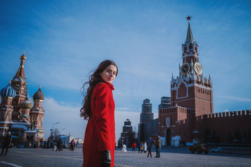 Happy women walking in red coat at the red square in Moscow