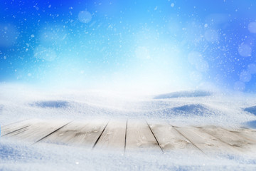 Decorative Christmas background with winter snowy blurred bokeh flakes of snow fall and empty wooden flooring