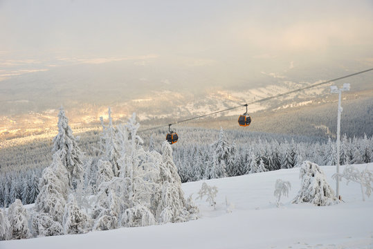 View on  Sweradow Zdroj resort in snowstorm, cable car in northern slope of Jizera Mountains, Poland