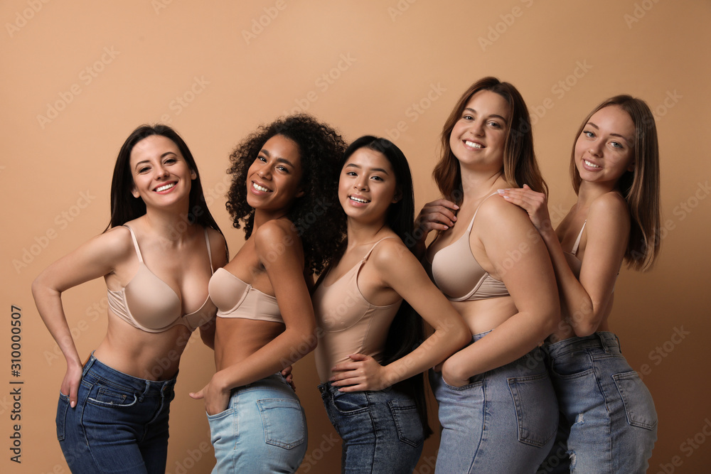 Wall mural group of women with different body types in jeans and underwear on beige background - Wall murals