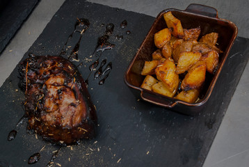  Pork with barbecue sauce cooked on the grill with baked potatoes.