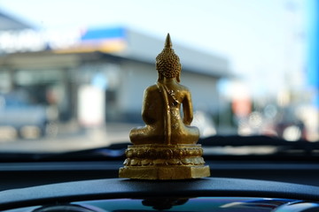 A driver put a Buddha image on a car console for protection.