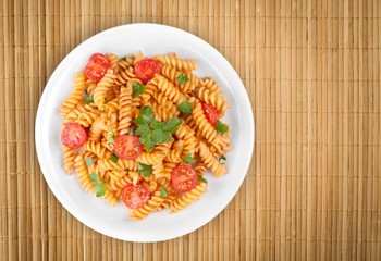 Spaghetti pasta with tomatoes and parsley on  table.