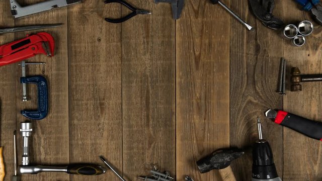 Different do it yourself hand tools moving on wooden background. Theme stop motion hand tools for logo intro. Concept of brand promotion for the provision of repair services, locksmith or woodworker.