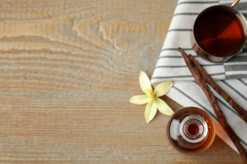 Flat lay composition with vanilla extract on wooden table. Space for text