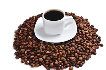 white cup of coffee on a white saucer stands on a hill of coffee beans on a white background  angle view from above