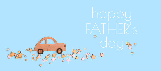 Happy Father's day greetings card. toy vintage car and star road, isolated on blue background. wooden car and many stars, flat lay.