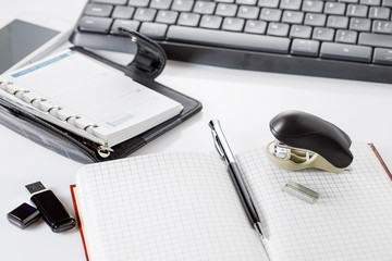 keyboard, notebook, stapler and pen on the table