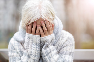 Senior woman covering face with her hands 