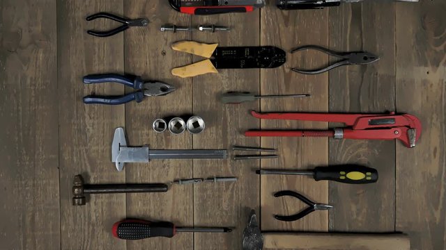 Animation of a hand tool for a home master on wooden background. Theme stop motion hand tools for logo intro. Concept of brand promotion for the provision of repair services, locksmith or woodworker.