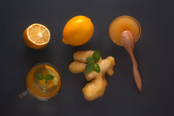 Ginger tea with lemon, honey and mint on a gray wooden table. Top view