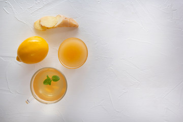 Tea with ginger, mint, lemon and honey on a white wooden table. Copy space. Top view