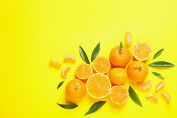 Fototapeta na wymiar Flat lay composition with fresh ripe tangerines and leaves on yellow background. Citrus fruit