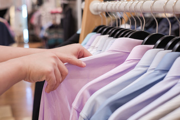 Cropped Hand Of Man choosing Men's shirts in clothing store