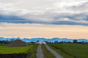Dirt road in front of an alpine panorama in the evening with the foehn weather