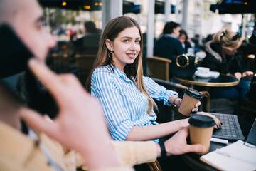 Confident female with laptop and coffee on terrace