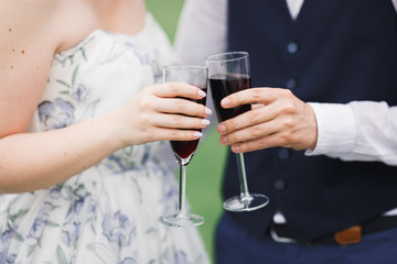Bride and groom holding glasses with champagne and clink
