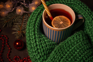 New year Christmas background. This is a Cup filled with a drink of red color, wrapped in a warm scarf and lying Christmas decorations. The concept of winter, solitude, Christmas, warmth and comfort.
