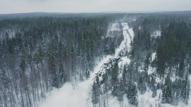 Aerial view retro steam train running backward in winter forest