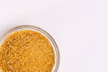Wheat groats in a plate on a white background. Groats in a small plate. Healthy breakfast on a white background.