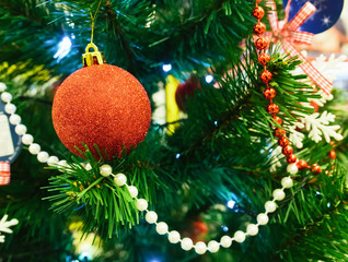 Festive decoration of the Christmas tree with Christmas toys and beads, to celebrate the new year