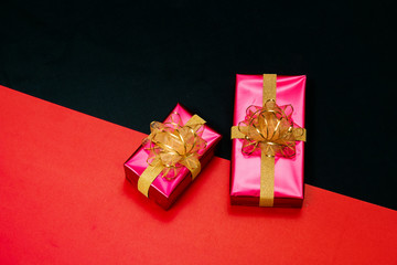 black gift box with black ribbons isolated on black background