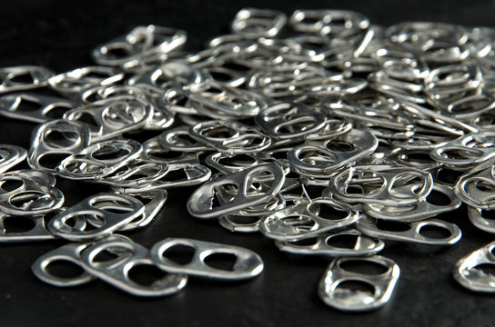 Recycling Beer And Pop Can Aluminum Tabs On Black Background