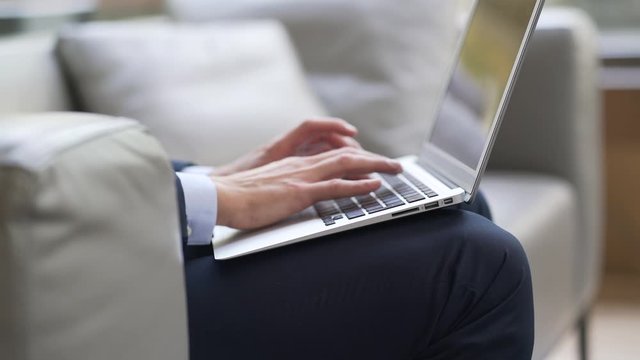 Closeup of businessman typing on laptop keyboard