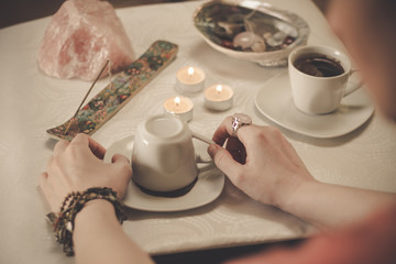 Coffee ground fortune teller, holding cup of coffee, close up