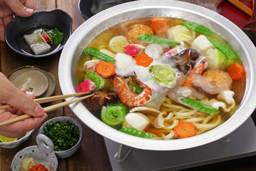 japanese cuisine, udon suki, hot pot with udon noodles and fresh vegetables and seafood