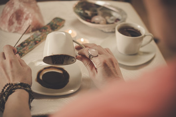 Coffee ground fortune teller, holding cup of coffee, close up