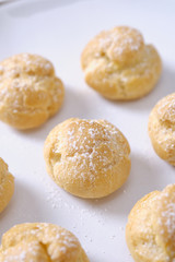 choux cream or cream puff or French profiteroles with fresh cream set on cafe table.