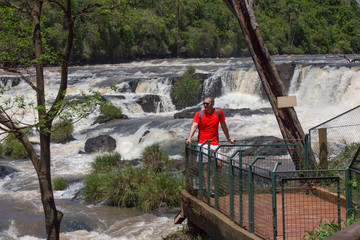 hombre posando en cascada con remera roja