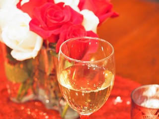 Christmas red and white roses with glass of white wine