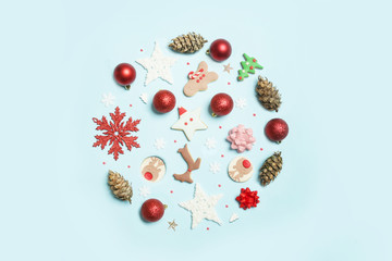 Christmas objects laid out in the shape of a Christmas bauble on pale blue background, top view. Christmas, winter holiday, new year concept.	